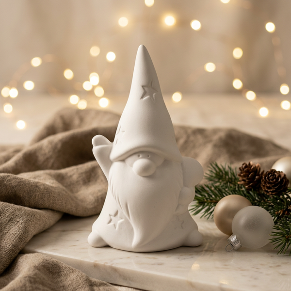 Anão de cerâmica perfumada branca, com gorro pontiagudo e estrelas em relevo, entre ramos e bolas de Natal.