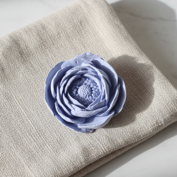 Cerâmica perfumada artesanal em formato de flor camélia com pétalas abertas.