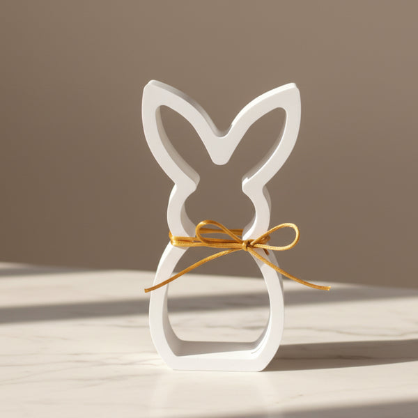 Coelho decorativo vazado branco com laço dourado para decoração minimalista de Páscoa.