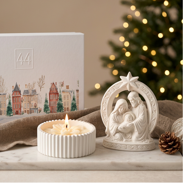 Coffret Presépio da 44, com vela acesa em pote de cerâmica canelada, presépio branco e caixa de oferta, em ambiente natalício.