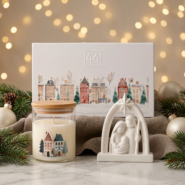 Coffret Premium da 44, com presépio branco, vela em vidro com tampa de bambu e caixa de oferta, em ambiente natalício.