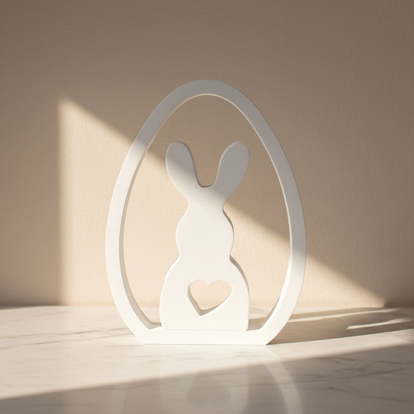 Enfeite decorativo de Páscoa com coelho dentro de ovo branco minimalista com recorte de coração.