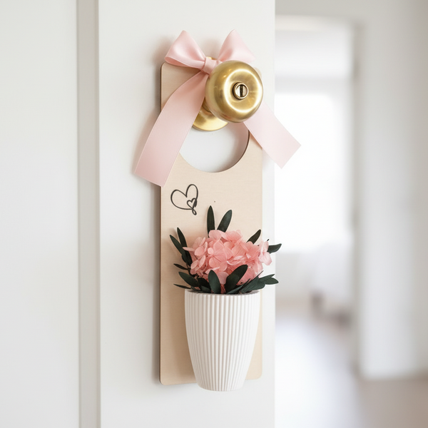 Pendente decorativo com laço rosa e vaso com flores secas em placa de madeira para porta.