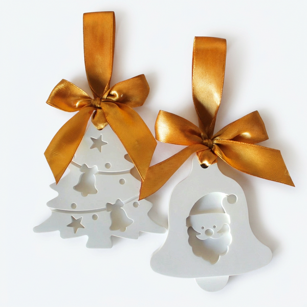 Pinheiro com motivos natalícios e sino com Pai Natal em relevo, com fitas douradas, sobre fundo claro.