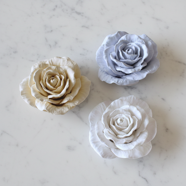 Cerâmicas perfumadas artesanais em formato de rosa alta com pétalas abertas.