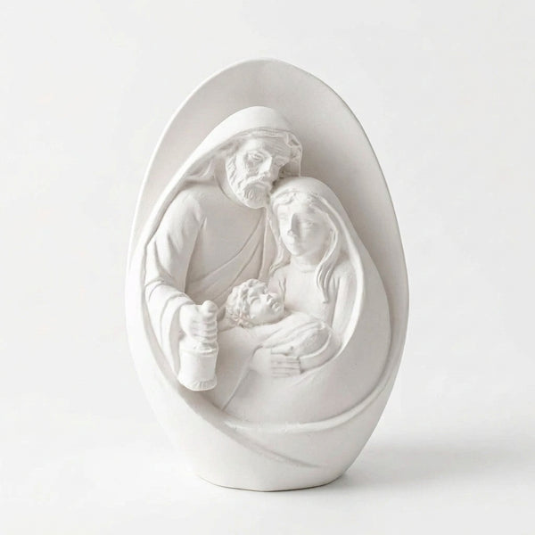 Vista frontal da Sagrada Família de cerâmica perfumada branca, com contorno oval e figuras em relevo, sobre fundo claro.