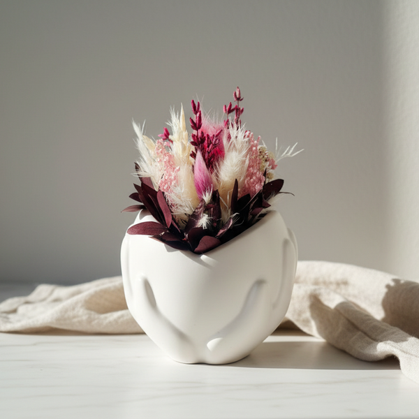 Vaso decorativo de cerâmica artesanal com coração nas mãos e flores preservadas estilo minimalista e romântico.
