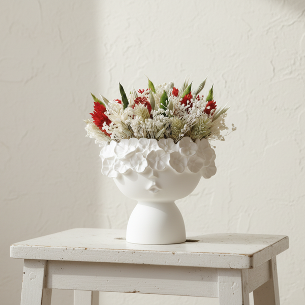 Vaso decorativo branco em formato de rosto feminino com flores secas estilo moderno minimalista.