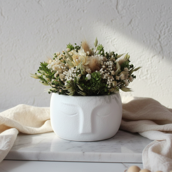 Vaso decorativo rosto estilizado com arranjo de flores secas decoração minimalista.