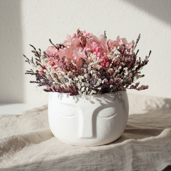 Vaso decorativo rosto estilizado com arranjo de flores secas decoração minimalista.
