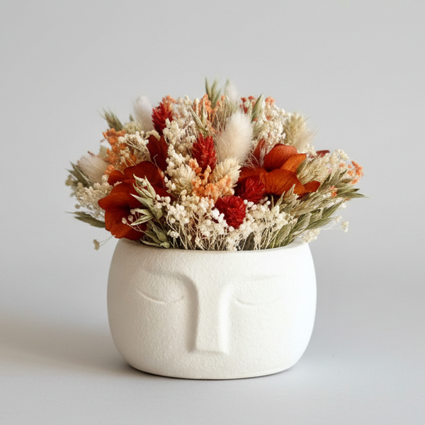 Vaso decorativo rosto estilizado minimalista com flores secas naturais em tons terra.