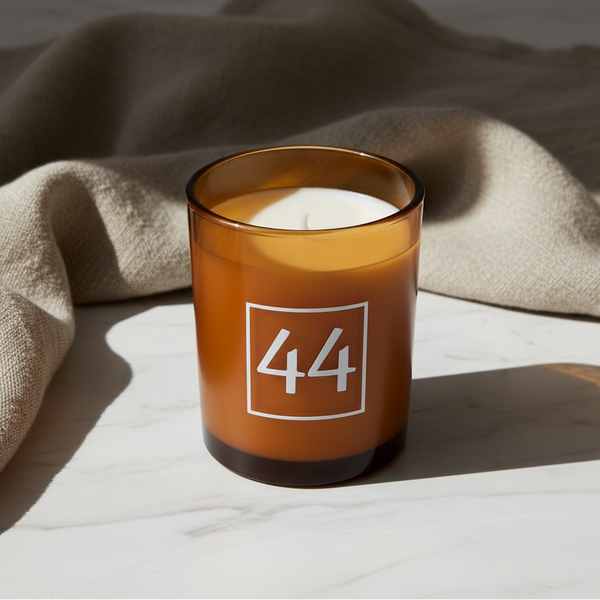 Vela aromática em copo âmbar produzida artesanalmente com cera vegetal.